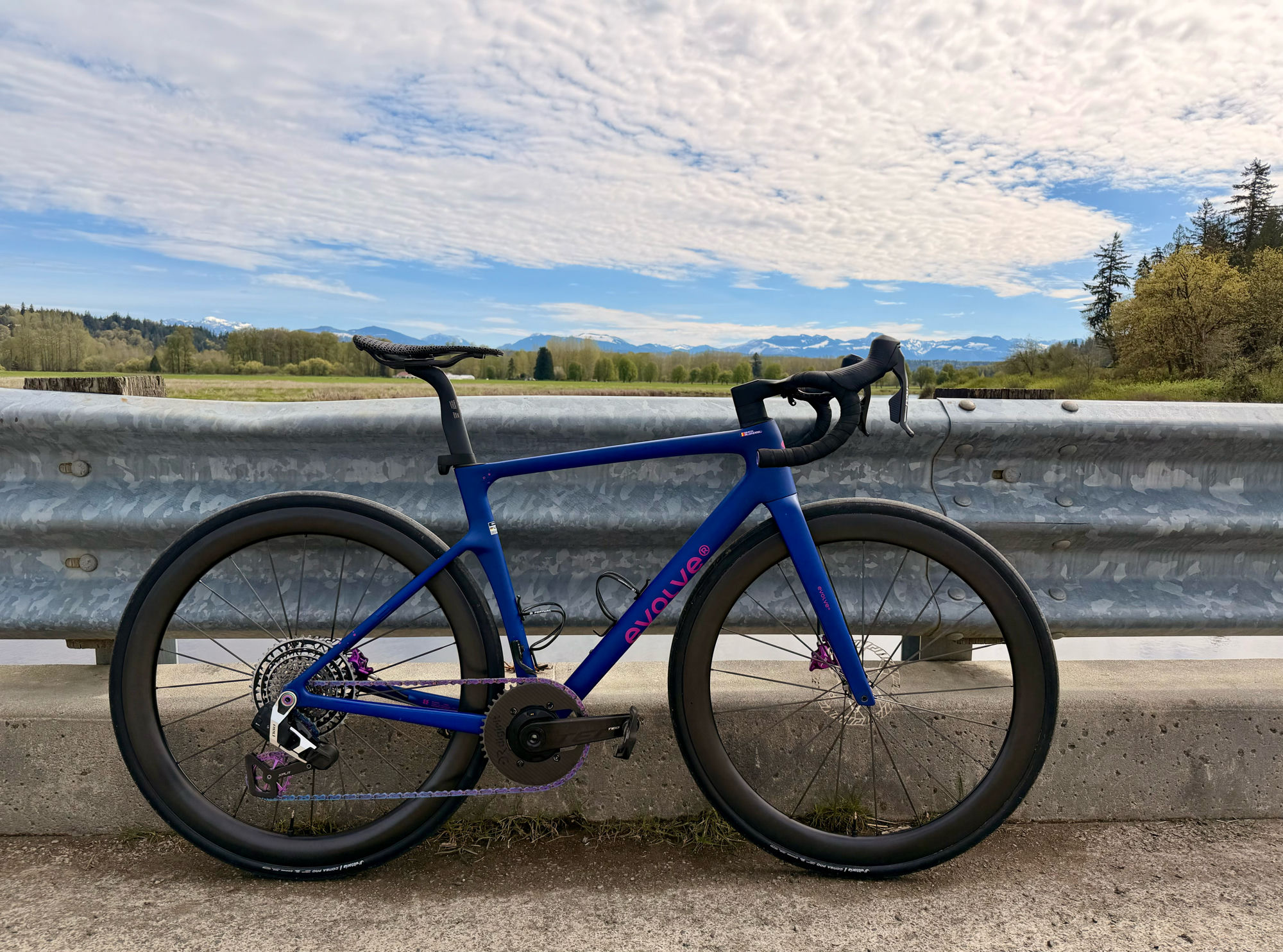 A Provara build — a blue carbon road bike on deep carbon wheels, North Cascades in the background.